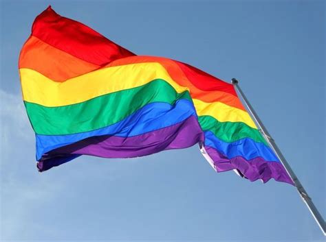 rainbow flag flying against blue sky symbol of gay pride
