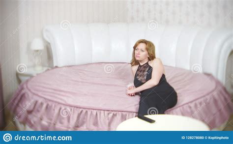 a sad woman sitting on the bed feels sad and bored