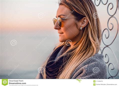 beautiful happy woman in sunglasses standing at the sea