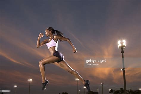 Athletic Black Woman Running At Track Under Lights Stock