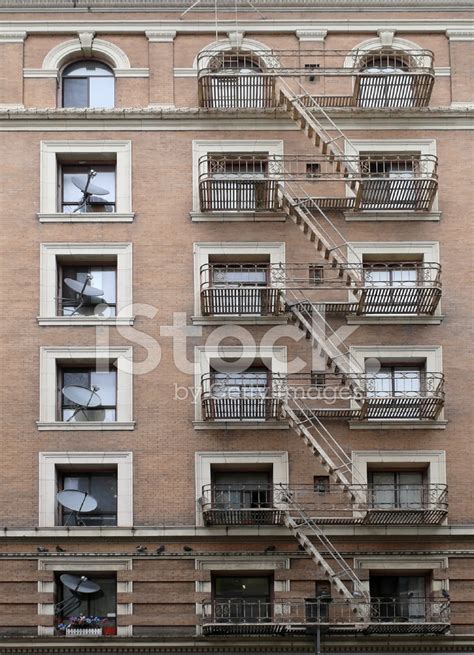 brick building with fire escape stairs and satellite