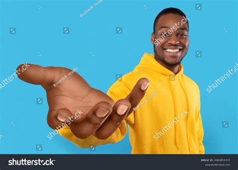 happy black guy showing big outstretched hand offering