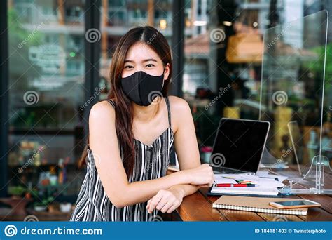 Young 20s Asian Woman Looking At Camera While Wearing A Protective Mask