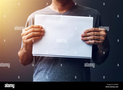 casual man holding blank  paper  mock  copy space  text  graphic design stock photo