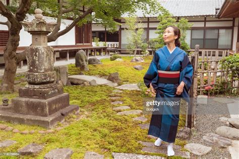 Mature Japanese Woman In Traditional Kimono Standing Outdoors Of Kyoto