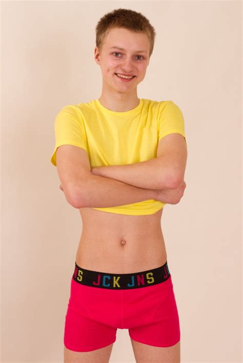twink smiles adorably as he poses in his tee shirt and hot
