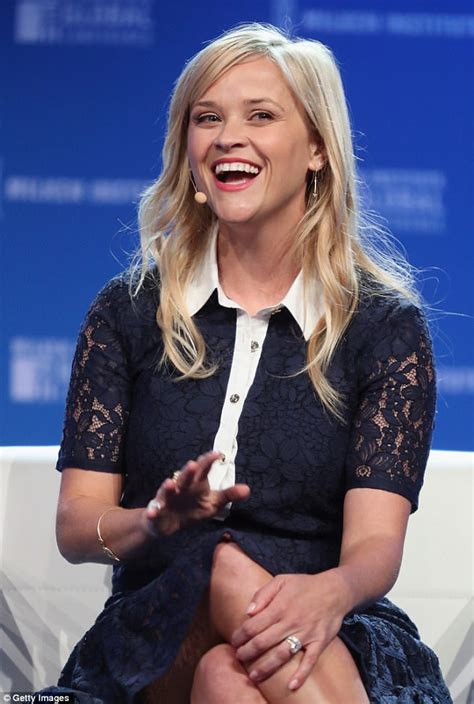 reese witherspoon flashes her legs in skirt and bright top