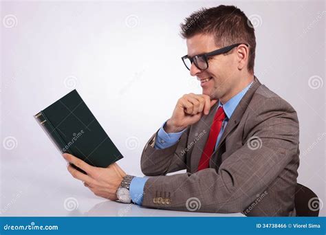 side  young business man reading  book  hand  chin stock photo