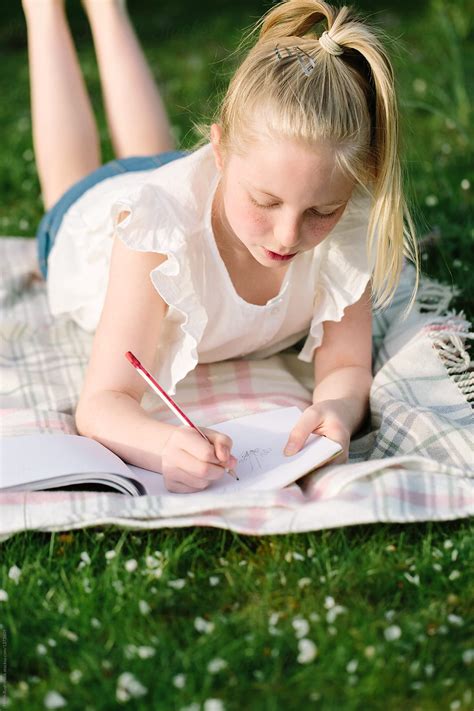 Tween Girl Drawing Outdoors In Early Summer By Stocksy Contributor