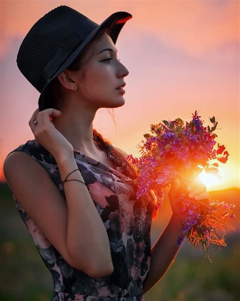 Cute Young Attractive Girl With A Bouquet Of Colorful Flowers In Her