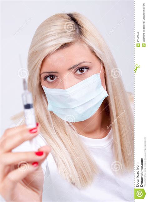 Female Doctor Or Nurse In Medical Mask Holding Syringe