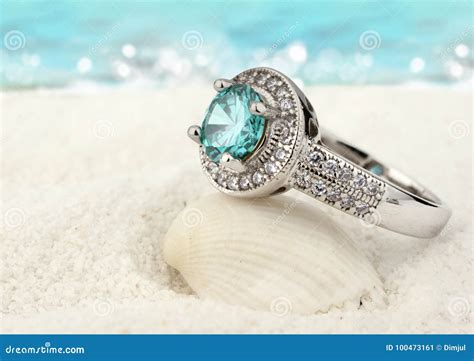 jewelry ring  clean aquamarine gem  sand beach background stock