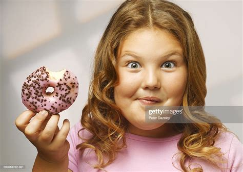 overweight girl eating doughnut smiling portrait closeup photo getty