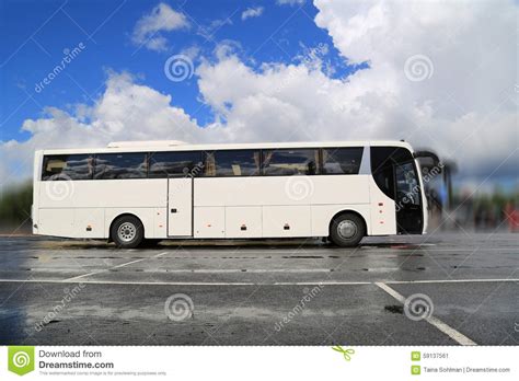 white coach bus waits for passengers on foggy rainy