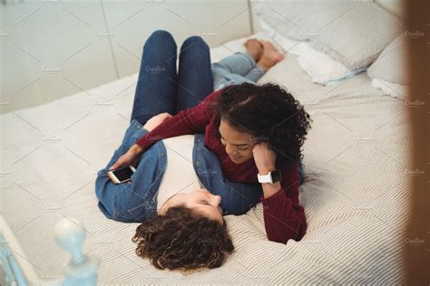 lesbian couple smiling while having a conversation on bed stock
