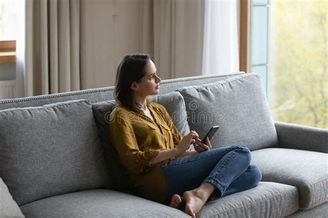thoughtful serious millennial girl using smartphone sitting on