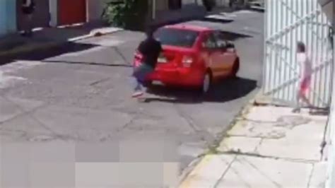 video ladrón arrastra a mujer para robarle su auto mientras su hijo