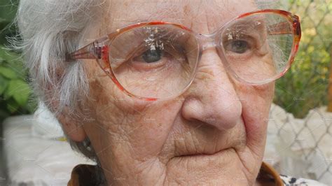 old woman in glasses looking forward and smiling portrait of happy