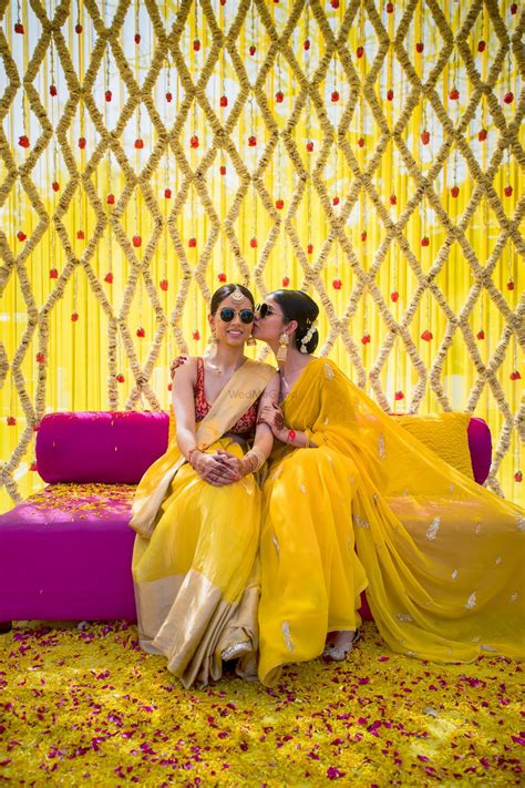 photo of two sisters pose together on the haldi ceremony