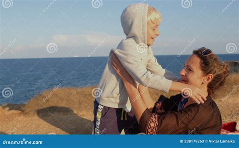Mom Takes Her Son With Her Hands At Height He Jumps Happily Twists