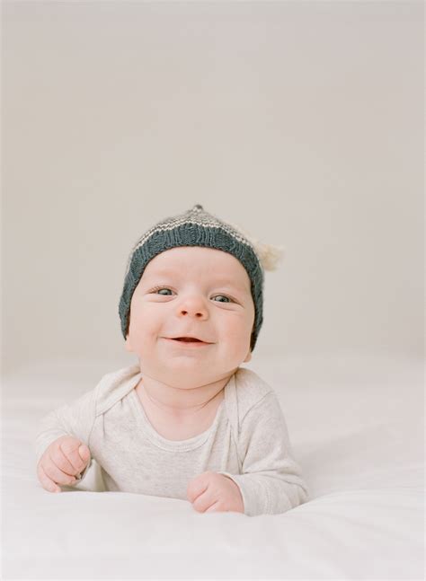 baby smiling big  neutral onesie  knitted hat seattle studio