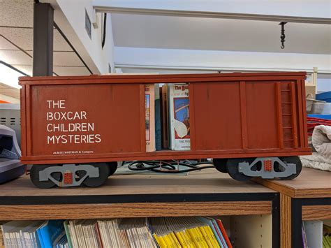 wooden boxcar   holding  boxcar children books mildly
