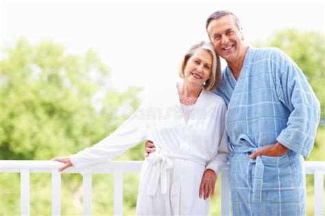 Mature Couple In Bathrobes Enjoying Their Retirement Vacation Cute