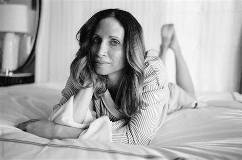 Black And White Portrait Of A Beautiful Woman Laying On A Hotel Bed