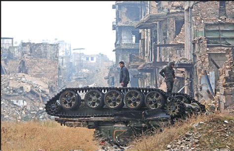 Forces Loyal To The Syrian Government Stand Atop A Damaged Tank Near