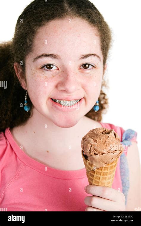 Portrait Of Cute Latina Girl With Curly Hair And Braces Holding A Yummy