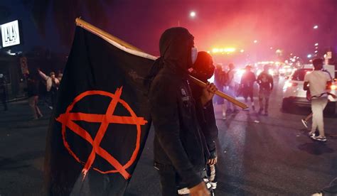 man carries  flag depicting  anarchist symbol   public disturbance  melrose