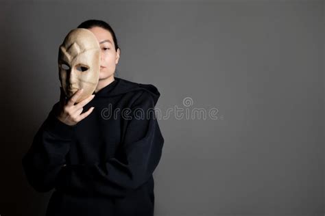 hiding   mask  young woman   dark hoodie hides  face   mask stock image