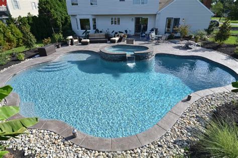 custom freeform style salt water inground pool  raised spa
