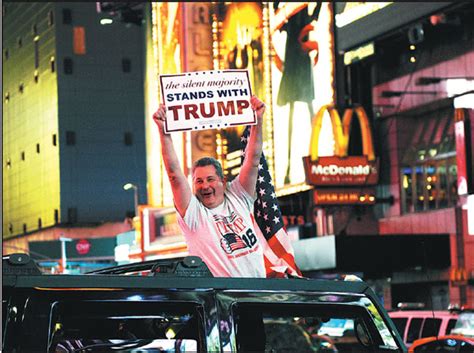 a man leans out of a car shouting words in support of