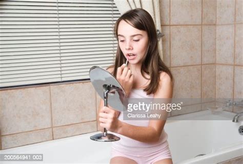 Girl Doing Make Up Sitting On Edge Of Bath In Bathroom Photo Getty Images