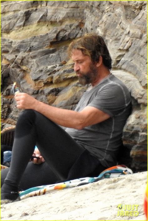 gerard butler puts on his skintight wetsuit for a day of surfing photo