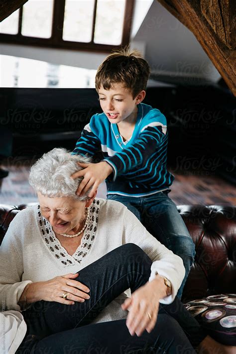 naughty grandson playing with grandma who is laughing with an