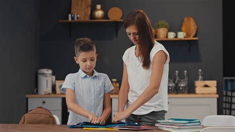 Mom Helps Her Son Prepare A Backpack For School Back To School Stock