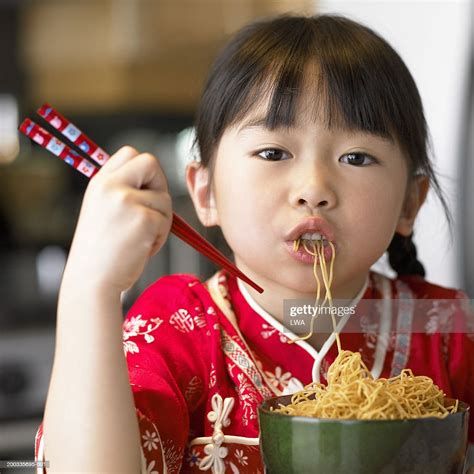 girl eating noodles with chopsticks portrait closeup photo getty images