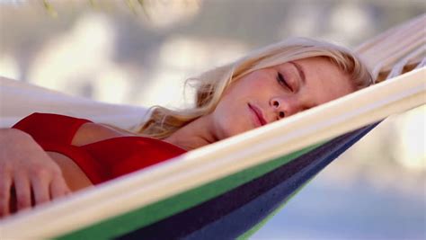 attractive blonde woman sleeping on a hammock on the beach stock footage video 4691885