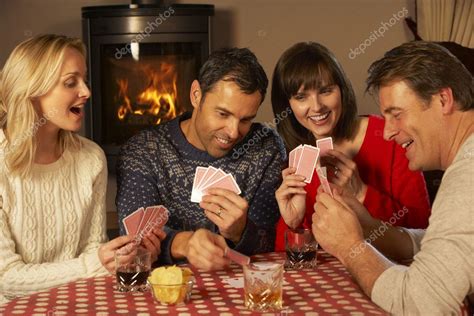 grupo de casais de meia idade jogando cartas juntos