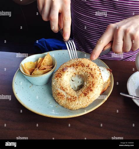 person eating bagel breakfast stock photo alamy
