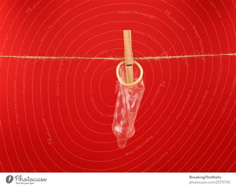 Close Up Condom Hanging On Washing Line Over Red A Royalty Free Stock