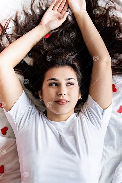 Young Happy Brunette Woman Laying In The Bed With Red Heart Shaped