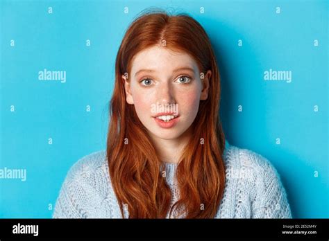 Headshot Of Cute Redhead Girl With Freckles Looking Hopeful And