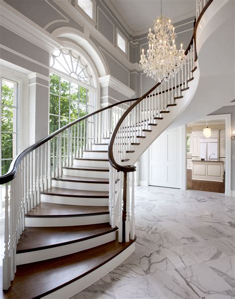 grande sweeping entry staircase  grey neutral foye  white