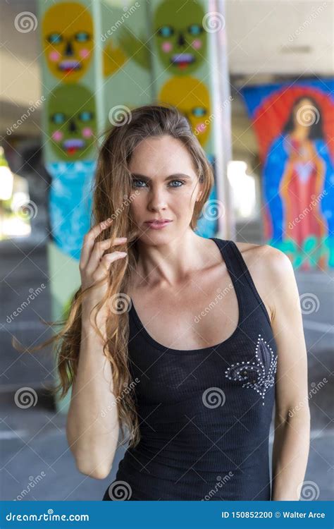 Lovely Brunette Model Posing Outdoors Against Graffiti Editorial Image