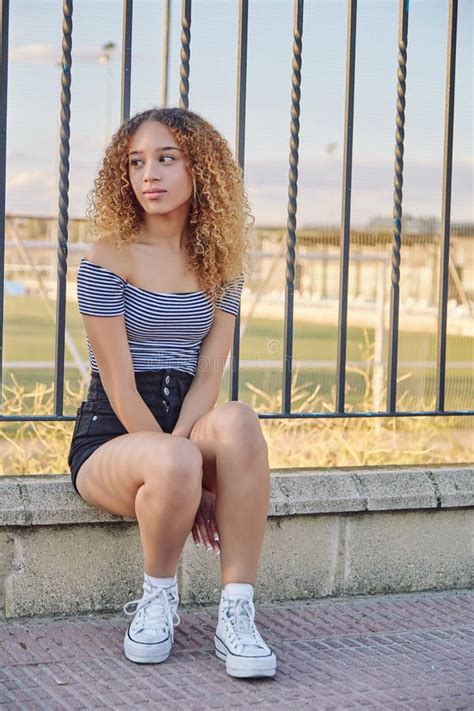 Young Curly Haired Latina Thought Sitting On A Fence Cute Latina Girl