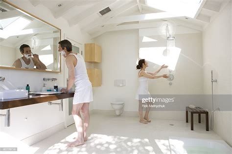 Man Shaving And Woman Testing Shower In Bathroom Photo Getty Images