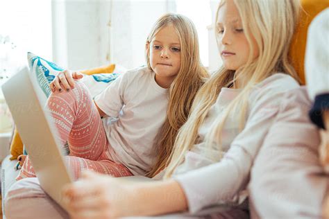 Teen Girls Watching Movie Together On Laptop Del Colaborador De